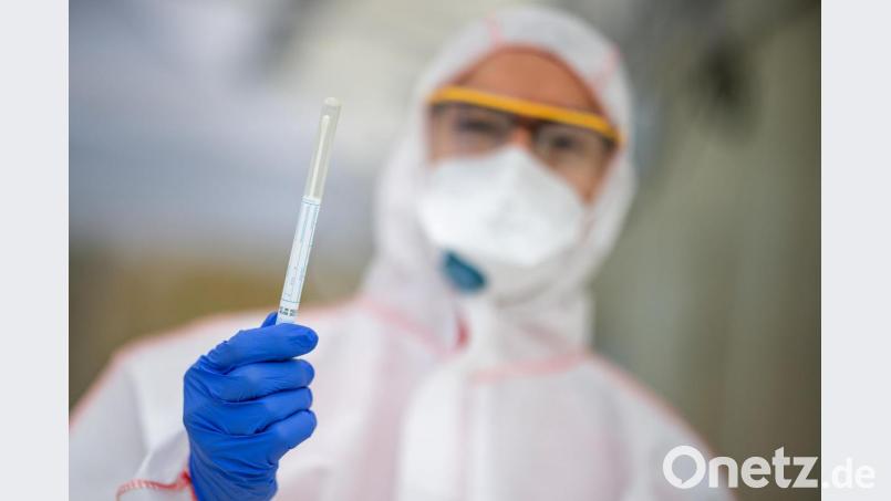 Ein Mitarbeiter hält in einem Corona-Abstrichzentrum einen Abstrich in der Hand, der dann benutzt wird, um einen Test auf das Coronavirus Sars-Cov-2 durchzuführen. Bild: Sebastian Gollnow/dpa