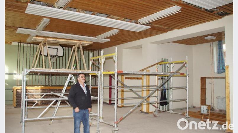 Bürgermeister Manfred Dirscherl nimmt die Arbeiten an der ehemaligen Schule in Weiding in Augenschein. In der Turnhalle werden demnächst die Deckenheizkörper eingebaut. Bild: mmj