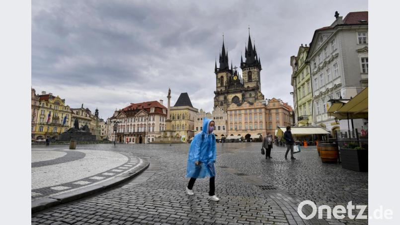 Eine Frau geht bei Regen durch die fast menschenleere Altstadt. Landesweit trat erneut der Notstand aufgrund der Corona-Pandemie in Kraft. Bild: VÌt Simanek