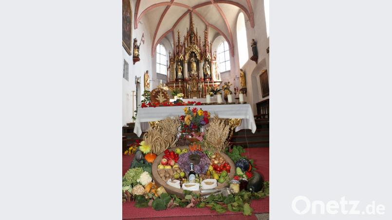 Andrea Zeitler und Martina Schreyer haben die Erntegaben in das „Rad des Lebens“ vor dem Altar aufgebaut. Bild: rpp