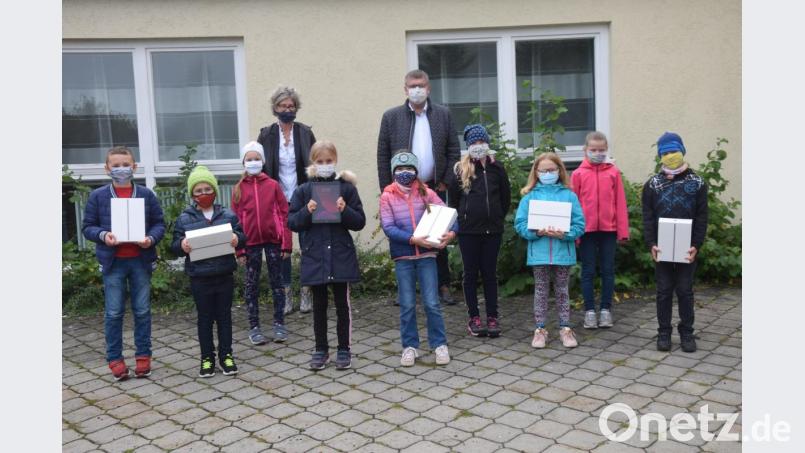 Unterstützung für das Lernen zuhause bekommen die Schmidmühlener Schüler. Bürgermeister Peter Braun (hinten rechts) übergibt zwölf neue Tablets an Rektorin Sabine Lubich (hinten links) für das &quot;Lernen zuhause&quot;. Bild: bö