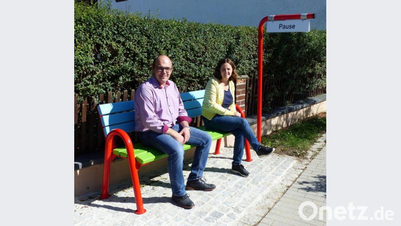ILE-Regionalmanagerin Annika Schreier und Bürgermeister Johannes Schmid nehmen auf dem &quot;Mitfahrerbankerl&quot; schon mal Platz. Das Schild zeigt an, dass beide darauf nur eine Pause machen. Bild: lgc