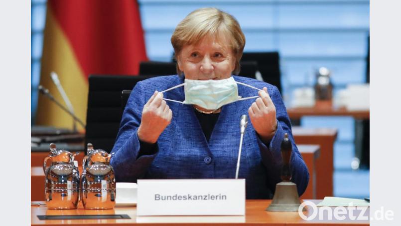 Bundeskanzlerin Angela Merkel (CDU) nimmt im Kanzleramt ihre Maske ab. Bild: Markus Schreiber/dpa