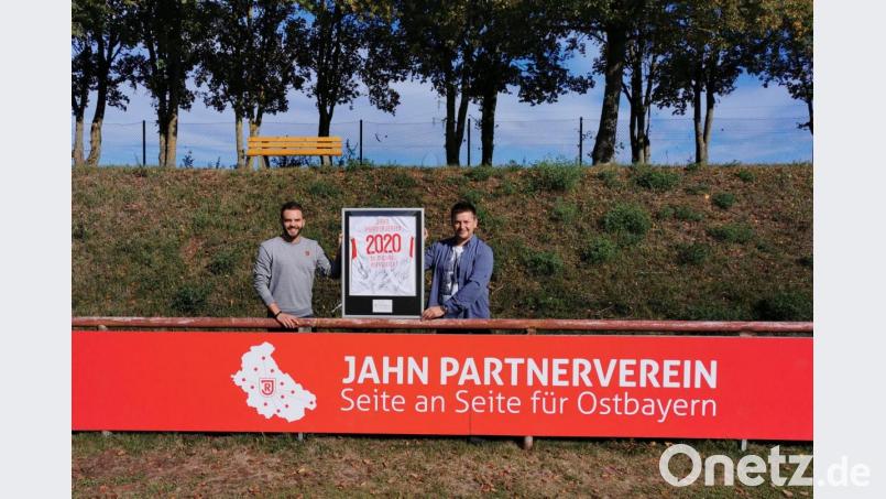 Sebastian Blödt (links) vom SSV Jahn Regensburg und Zweiter Vorsitzende Franz Schubert (rechts) vom SV Michaelpoppenricht freuen sich bei der Übergabe der Bandenwerbung über die Vereinspartnerschaft. Dazu gibt es auch noch einen Trikotsatz. Bild: ew