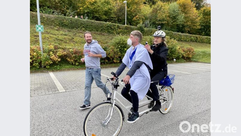 Woidboy Andi Weindl lässt sich während einer Tandemfahrt vom Kastler Boder die Haare schneiden, während Uli Nutz nebenher joggt und sich mit dem Friseur unterhält. Bild: Eva Schatz/BR