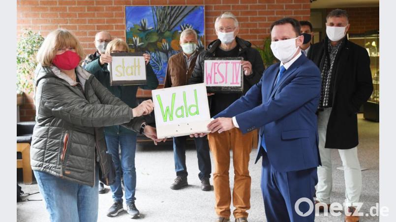 Ein schweres Päckchen mit dem Titel „Wald statt West IV“ im Gepäck: Das Aktionsbündnis Walderhalt überreicht 2900 Unterschriften an Oberbürgermeister Jens Meyer. Sie fordern die Stadt Weiden auf, auf die weiteren Planungen für ein neues Gewerbegebiet in Weiden West zu verzichten. Wichtige Weichen soll dazu das Bürgerbegehren stellen. Bild: Gabi Schönberger