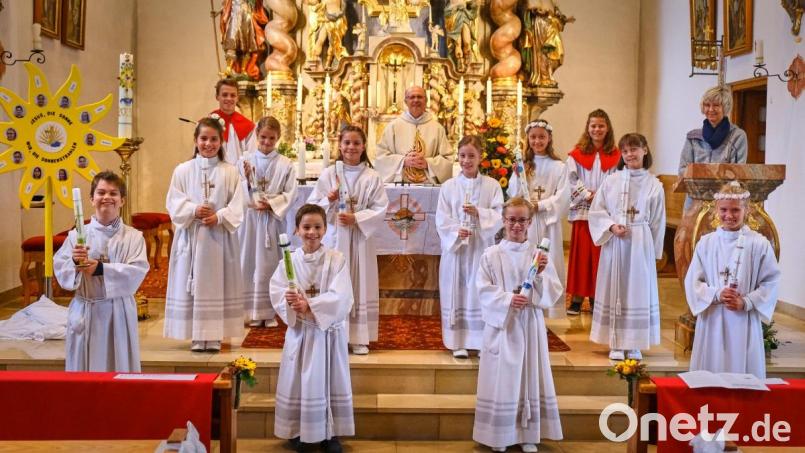 Die Kommunionkinder postierten sich zusammen mit Pfarrer Hebert Rösl (hinten, Mitte) und Schulleiterin Friderike Bösl (hinten rechts) neben der symbolischen Sonne mit dem Motto: &quot;Jesus, die Sonne - Wir, die Sonnenstrahlen.&quot; Bild: tkr