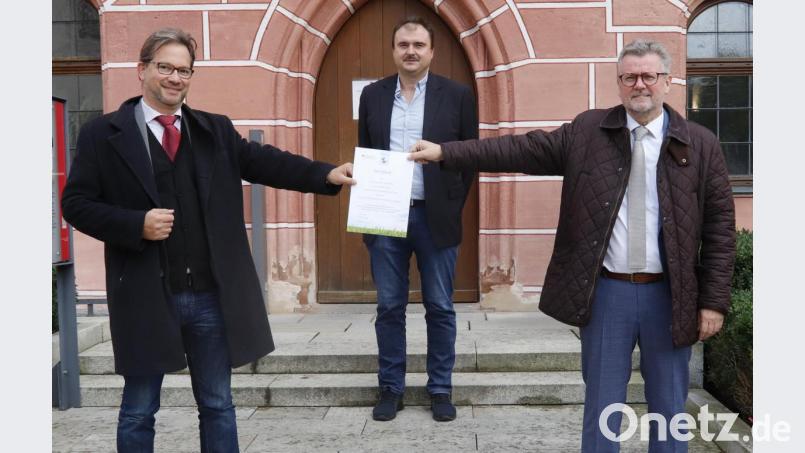 Ein Klimaschutzzertifikat des Bundesumweltministeriums würdigt die Erfolge bei der Umrüstung der Straßenlampen in Sulzbach-Rosenberg. Von links Parlamentarischer Staatssekretär Florian Pronold, Elektromeister Roland Segerer und Bürgermeister Michael Göth. Bild: mfh