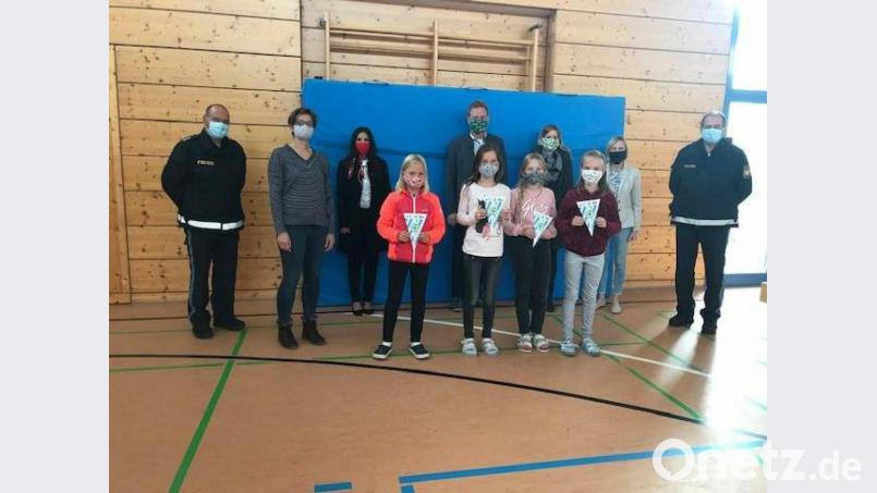 45 Viertklässler der Freudenberger Grundschule absolvieren ihre Radfahrprüfung. Vier Mädchen schaffen den theoretischen und praktischen Teil so gut, dass sie mit einem Ehrenwimpel belohnt werden. Es gratulieren (von links): Polizeihauptkommissar Harald Heselmann, Lehrerin Ingrid Augsberger, Sparkassenmitarbeiterin Yvonne Matar, Bürgermeister Alwin Märkl, Elternbeirätin Martina Ott, Rektorin Gabriele Krettner und Polizeihauptkommissar Horst Strehl. Bild: u