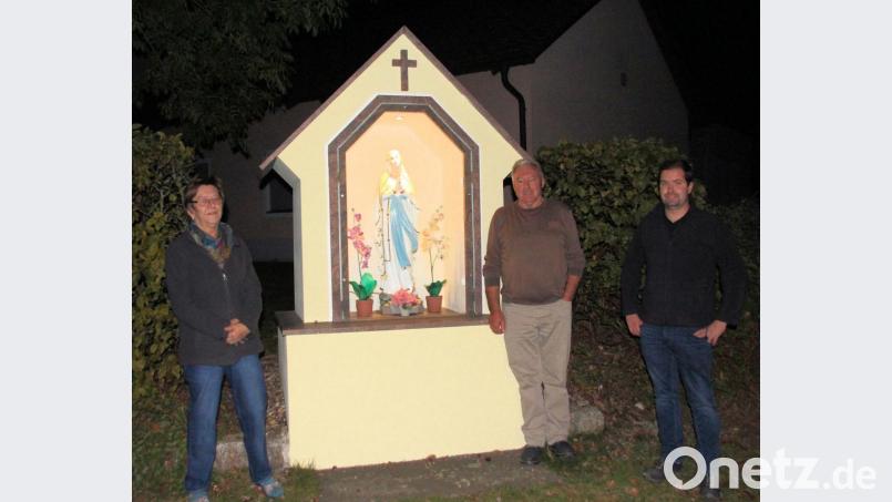 Die Muttergottesfigur im Marterl vor dem Dorfgemeinschaftshaus wird nun mit einem Solarlicht beleuchtet (von links): Annemarie Spies, Vorsitzender Georg Koller und Elektriker Benjamin Fritz. Bild: bjo