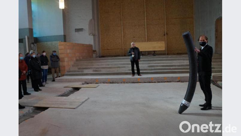 Stadtpfarrer Stefan Wagner (rechts) zeigte die Rohre, innerhalb derer die Leitungen für die Heizung der Kirche im Fußboden verlegt wurden. Architekt Michael Steidl (im Hintergrund) gab dazu Erklärungen. Bild: wel