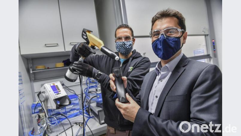 Mit einer solchen Sprühpistole, wie sie Andreas Rank (links) hält, werden Kunststoffwerkstücke in der Hand von Felipe Wolff-Fabris lackiert. Bild: Florian Miedl/fph