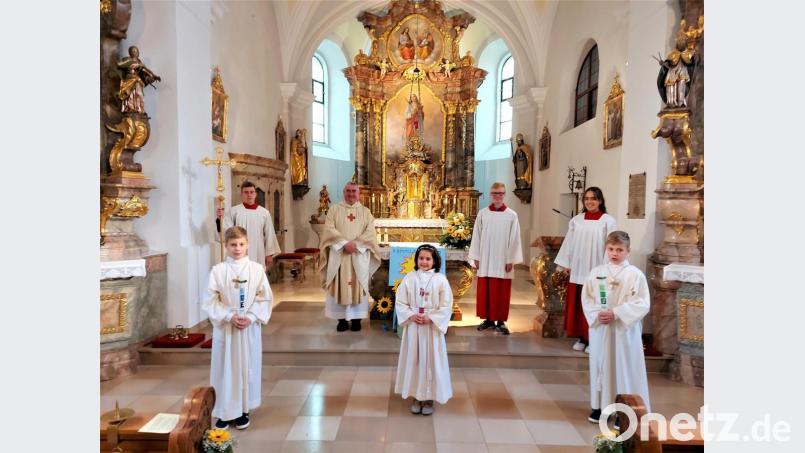 Die Kommunionkinder Alexander Scheuerer (von links), Selina Zwick und Thomas Scheuerer zusammen mit Stadtpfarrer Alfons Kaufmann und den Ministranten. Bild: lg