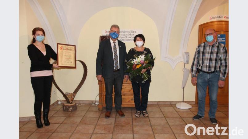 Bürgermeisterin Marina Hirnet (links) und ihr Stellvertreter Rudolf Völkl (rechts) zeichnen Johann Maurer mit dem Ehrentitel &quot;Altbürgermeister&quot; aus. Maurers Ehefrau Hannelore freut sich über Blumen. Bild: pi