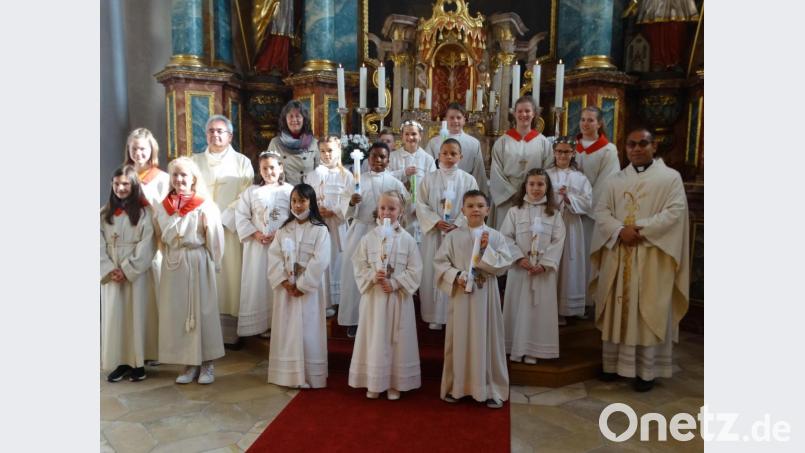 Zwölf Kinder empfingen in der Pfarrkirche St. Georg in Schlicht die Erstkommunion. Zusammen mit den Ministranten, Pfarrvikar Jimmy Joseph (rechts), Diakon Dieter Gerstacker und GVT-Leiterin Monika Krieger stellten sie sich nach dem Gottesdienst vor dem Hochaltar zum Erinnerungsfoto auf. Bild: ct