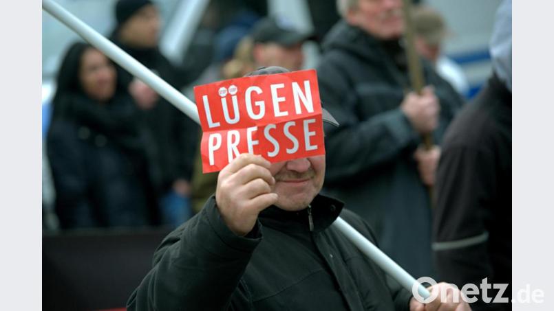 Ein Mann zeigt bei einer Demonstration eines rechtspopulistischen Bürgerbündnisses dem Fotografen ein Schild mit der Aufschrift „Lügenpresse“. Archivbild: Paul Zinken/dpa