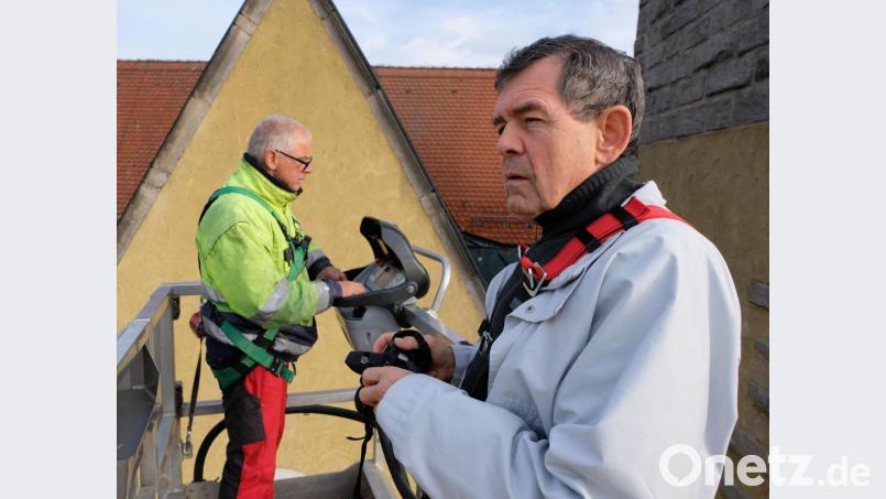 Pfarrer Max Früchtl beobachtet die Demontage des Kirchturmkreuzes vom Hochkran aus. Das Wahrzeichen wird nun statisch begutachtet und dann saniert. Bild: le