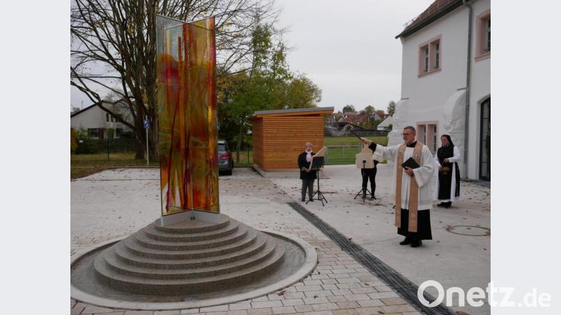 Pfarrer Dr. Thomas Vogl bei der Segnung des Brunnens und der Außenanlagen. Im Hintergrund das Harfentrio mit (von links) Isabella Buchwald, Sandra Lang und Schwester Sophia Schlembach. Bild: hmr