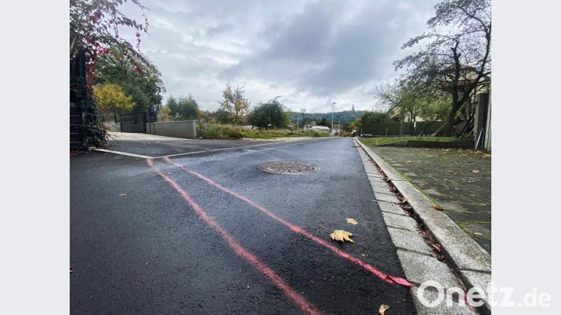 Zwei rote Striche quer über die Dostlerstraße zeigen, wo die „Mauer“ etwa entstehen müsste, damit sie sicherstellt, dass die Stadt die Kosten der Erschließung des Ostteils auf die Anwohner umlegen könnte. Im Hintergrund das noch unbebaute Grundstück, auf dem fünf Wohnhäuser gebaut werden können. Bild: Petra Hartl