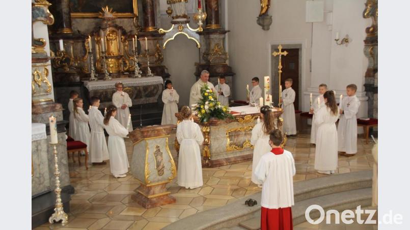 Vor dem Empfang der ersten Kommunion versprachen die Ertskommunikanten mit der Kommunionkerze am Altar stehend, durch Worte und Taten für ihre Mitmenschen Licht in das Dunkel dieser Welt zu bringen. Bild: frd