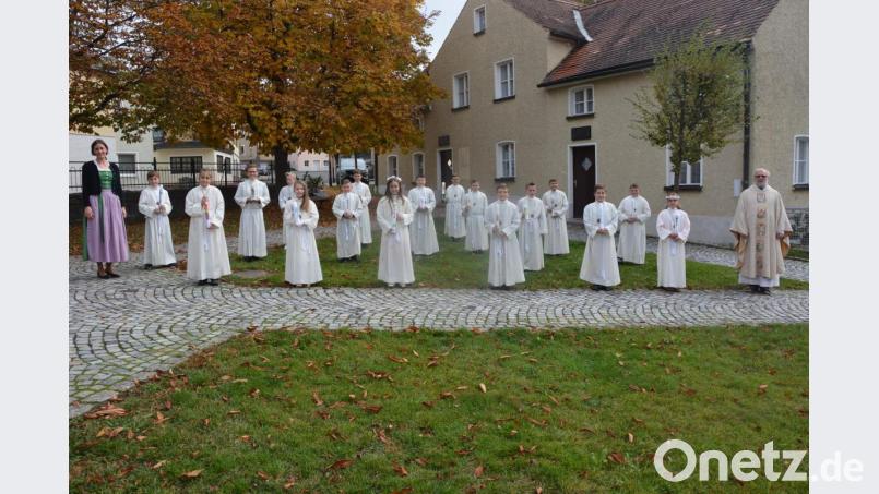 Die 17 Erstkommunionkinder der Pfarrei St. Laurentius mit Pfarrseelsorger Pater Benedikt Leitmayr (rechts) und Klassen- und Schulleiterin Johanna Reger (links). Bild: jr