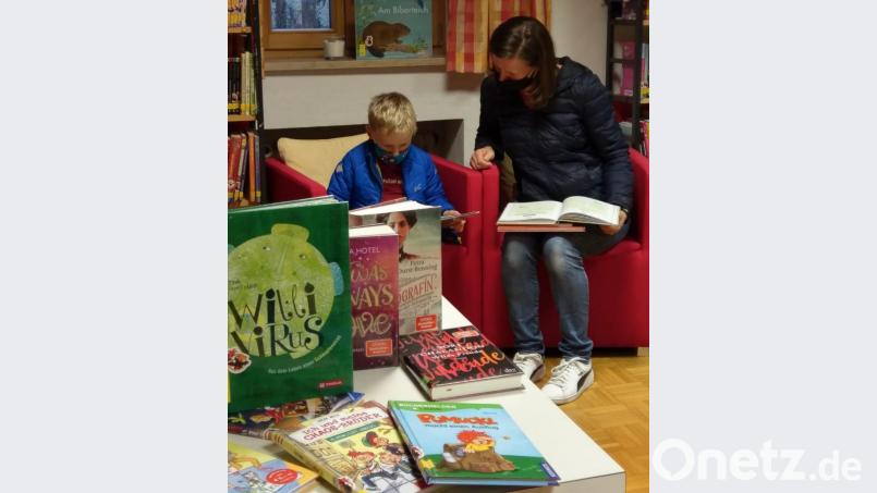 Voller Leidenschaft schmökert eine Mama mit ihrem Sohn in der Waldthurner Bücherei in den neuen Büchern. Bild: fvo