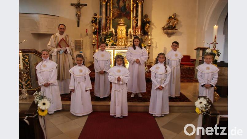 Die erste Gruppe der Kommunionkinder. Das vermutlich wichtigste Accessoire war der weiße Mund-Nasen-Schutz, den die Kinder nur für das Foto runterschoben. Bild: ral