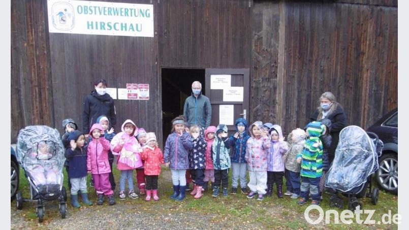 Roland Maier (Mitte), der Vorsitzende des Obst- und Gartenbauvereins, erklärt den Mädchen und Buben des Marienkindergartens mit Leiterin Christa Bauer (links) den Vorgang der Saftherstellung vom Anliefern der Äpfel über das Pressen bis hin zum Abfüllen. Bild: u