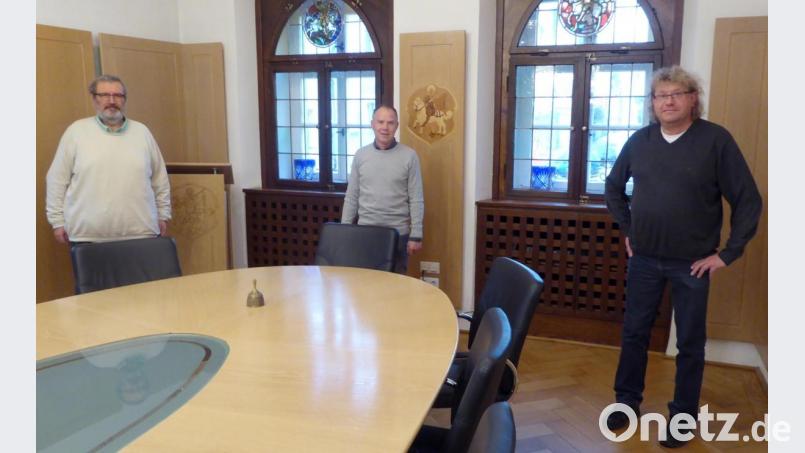 Alle drei Fraktionsvorsitzenden Gerhard Steiner (von links), Rainer Hetz und Thomas Hauer des Neustädter Stadtrat stellen sich im Sitzungssaal hinter den Stuhl des Bürgermeisters, um die Solidarität mit seinen Aussagen gegen die Querdenker-Demo zu symbolisieren. Bild: fsb