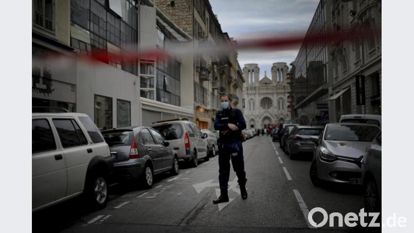 Ein französischer Polizist steht nach einem Messerangriff hinter einer Absperrung zu Beginn der Straße, die zur Kirche Notre-Dame in der südfranzösischen Küstenstadt Nizza führt. Bild: Daniel Cole/AP/dpa