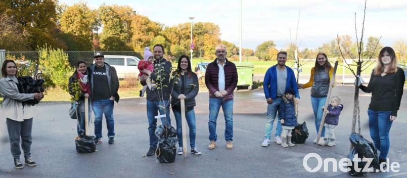 Bürgermeister Roger Hoffmann (Vierter von rechts) übergibt die von den Häuslebauern ausgewählten Obstbäume mit dem gutgemeinten Rat, in der Anwachszeit immer reichlich zu gießen. Bild: gf