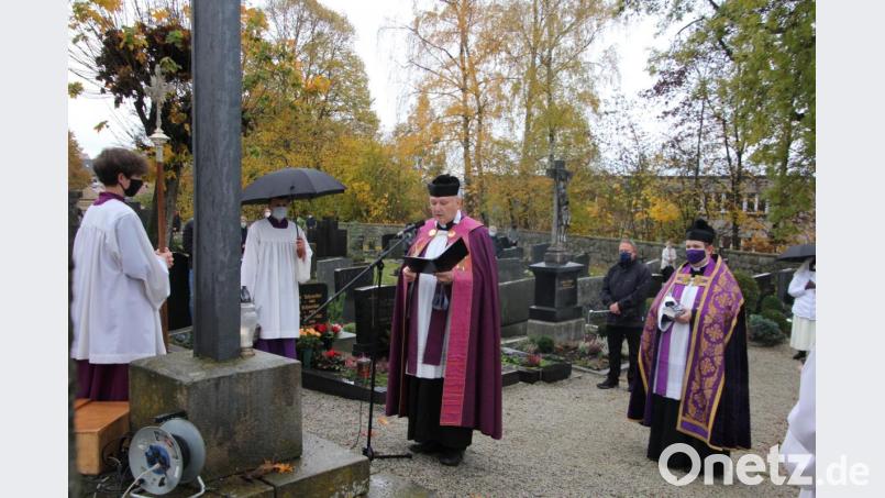 Stadtpfarrer Georg Flierl (links) und Kaplan Daniel Fenk beteten am Friedhofskreuz. Bild: kro
