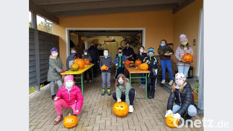 Kinder fertigten Herbst- oder Halloween-Kürbisse mit großer Begeisterung unter Leitung von Claudia Landgraf-Spendel, Daniela Stahl (von rechts) und unterstützt von Christian Landgraf. Bild: gi