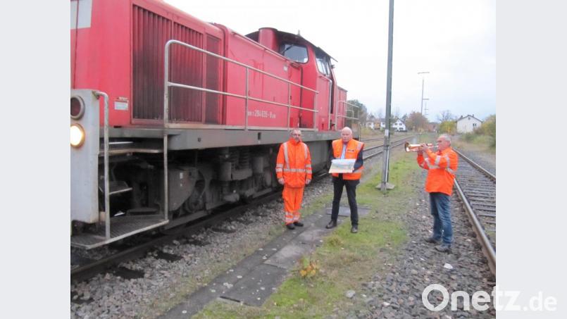 Feierabend für Herbert Rauch: Claus Barth, der Leiter des Güterverkehrs der DB Nordostbayern, verabschiedet ihn zusammen mit Trompeter Franz Enderer nach seiner letzten Fahrt am Hirschauer Bahnhof. Bild: fg