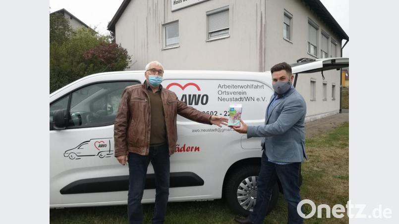 Bürgermeister Sebastian Dippold überreicht dem AWO-Vorsitzenden Franz Witt Desinfektionsmittel und Reinigungstücher für das neue Lieferfahrzeug, mit dem &quot;Essen auf Rädern&quot; ausgefahren wird. Bild: prh