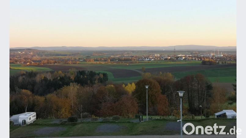 Wenn die Herbstsonne an einem wolkenlosen Tag untergeht, ist der Ausblick von Großbüchlberg aus besonders reizvoll. Hinten rechts zu sehen ist Mitterteich, hinten links Leonberg. Vorne im Bild einige Stellplätze des derzeit verlassenen Campingplatzes. Bild: lnz