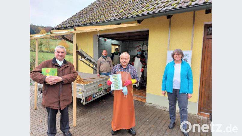 Während im Hintergrund die Obstpresse auf Hochtouren lief, übergab OGV-Vorsitzender Karl Ruhland (Mitte) die 500-Euro-Spende an Stadtpfarrer Alfons Kaufmann (links). Bild: lg