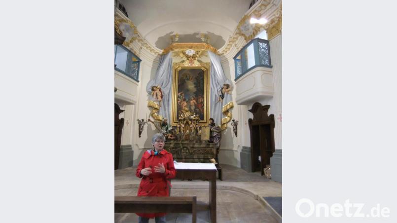 Den schön restaurierten Hochaltar in der Ebermannsdorfer Johanniskirche erläutert Heimatpflegerin Christine Schormüler. Sie bezeichnet das geschichtsträchtige Gotteshaus als Kulturdenkmal. Bild: gm
