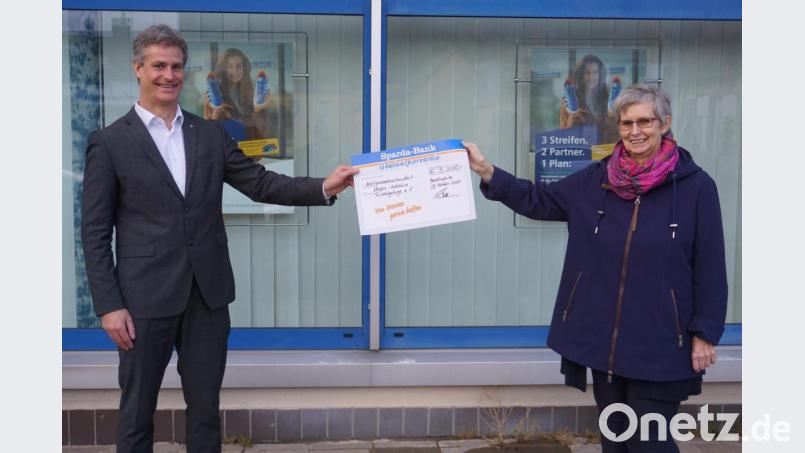 Filialleiter Mathias Späth übergibt den symbolischen Spendenscheck an Helga Scherzer-Kaufmann von der Hospiz-Initiative Fichtelgebirge. Bild: fph