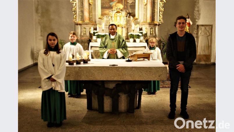 Pfarrer Cyprian Anyanwu nahm Marie Zeitler (links) in die Schar der Ministranten auf und verabschiedete langjährige Messdiener. Bild: Joachim Kellner/exb