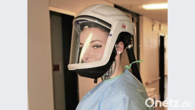 Eine Pflegekraft mit Atemschutzhelm – diese Helme werden derzeit im St.-Anna-Krankenhaus getestet, anschließend wird über die Anschaffung für die Mitarbeiter im Isolations-Bereich und in der Notaufnahme entschieden. Ein Gebläsefilter auf dem Rücken sorgt dafür, dass ständig ein gereinigter, frischer Luftstrom vor das Gesicht des Trägers transportiert wird. Bild: Marie Ehras/exb