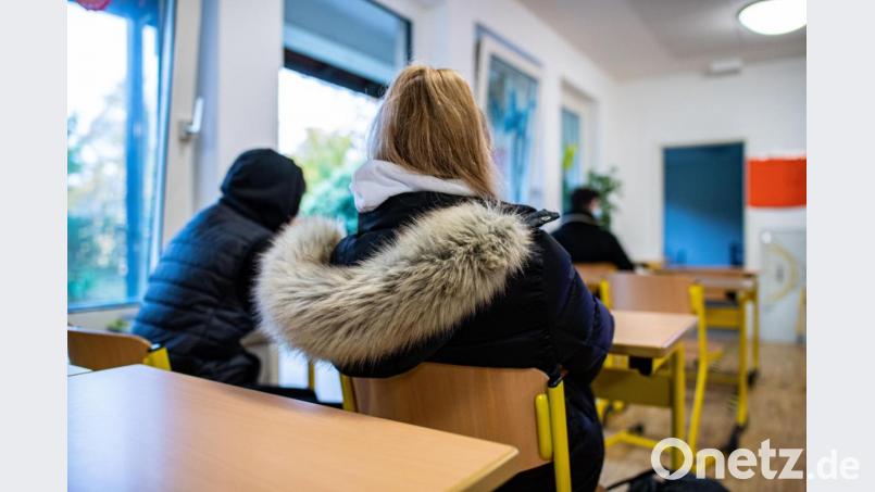 Eine Schülerin sitzt zum Schulbeginn nach den Herbstferien mit ihrer Winterjacke bei geöffneten Fenstern in einer Klasse: Den Amberger Wirtschaftsschülern bleibt das durch einen glückliche Fügung erspart. Symbolbild: Guido Kirchner/dpa