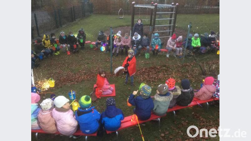 Martinsfeier in Coronazeiten: Durch einen Maschendrahtzaun voneinander getrennt verfolgten die Schul- beziehungsweise Krippen- und Kindergartenkinder das Martinsspiel. Bild: u