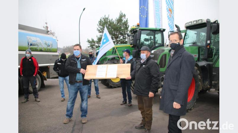 Ein dickes Preisbrett zum Bohren übergaben die Milchbauern dem Bechtel-Bereichsleiter Georg Müller. (rechts). Bild: jrh