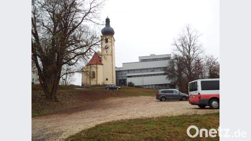 Der Blick vom Dorfplatz hinauf zur Kirche. Wo heute eine Parkpfläche zu sehen ist, soll einst eine Parkterrasse vom Dorfplatz zur Kirchen hinauf führen. Auf der linken Seite könnten sich die Planer bewachsene Gabionen vorstellen. Bild: e
