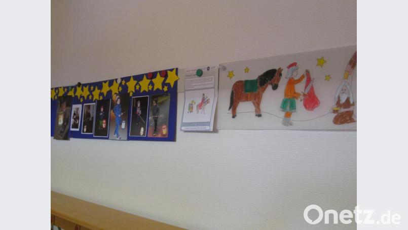 An einer Wand im Kindergarten wurden gemalte Bilder vom heiligen Martin und Fotos von abendlichen Spaziergängen der Eltern mit ihren Kindern geklebt. Bild: Kerstin Pflaum/exb