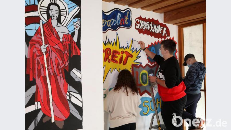 Eine Wand zeigt das Kirchenfenster mit dem Erlöser und daneben die Themen der Schüler im Graffiti-Stil. Bild: Wolfgang Steinbacher
