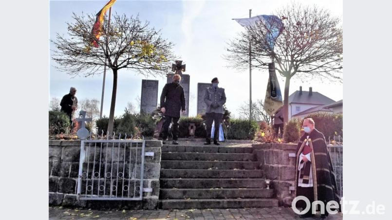 Zweiter Bürgermeister Hermann Schraml und KSK-Vorsitzender Karl Reger (Mitte von links) legten am Ehrenmal Kränze nieder. Pfarrer Heribert Stretz sprach ein Gebet und gedachte mit Fürbitten aller Opfer (rechts). Bild: hl