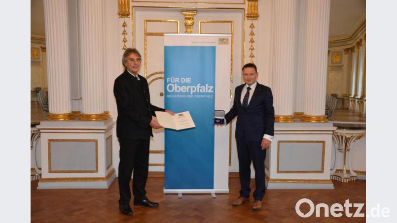 Regierungspräsident Axel Bartelt (links) überreicht die Kommunale Verdienstmedaille in Bronze an Weidens Oberbürgermeister Jens Meyer. Bild: Regierung der Oberpfalz/Stühlinger