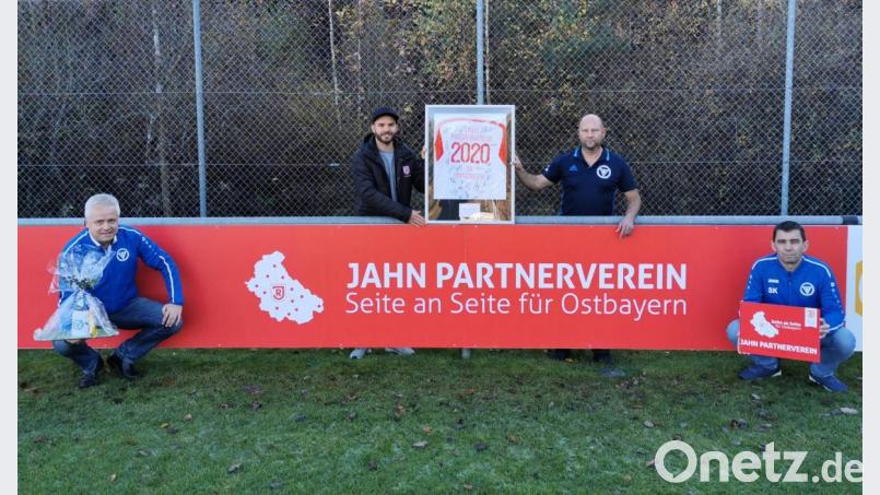Ein Trikot mit allen Unterschriften der Jahn-Spieler der aktuellen Mannschaft der 2. Bundesliga brachte Sebastian Blödt (Zweiter von links) nach Immenreuth als Gastgeschenk mit. Vorsitzender Jürgen Lautner (rechts daneben) freute sich mit seinem Stellvertreter und Jugendleiter Stefan König (rechts) über die Jahn-Kooperation, genauso wie SV-Ehrenamtsbeauftragter Roman Melzner (links). Bild: mez